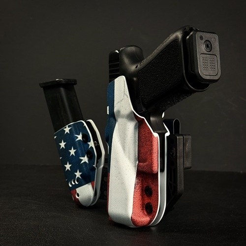 Compact handgun wrapped in an American flag design on a dark surface