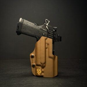 2011x300Aciton - Superstition Concealment Black semi-automatic pistol in a tan polymer holster on a dark surface.